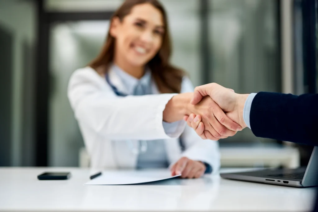 a smiling female doctor handshakes with a male pat 2026 01 08 08 15 36 utc